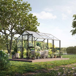 Stilfuldt drivhus på træterrasse i haven Moderne sort drivhus med planter og havemøbler