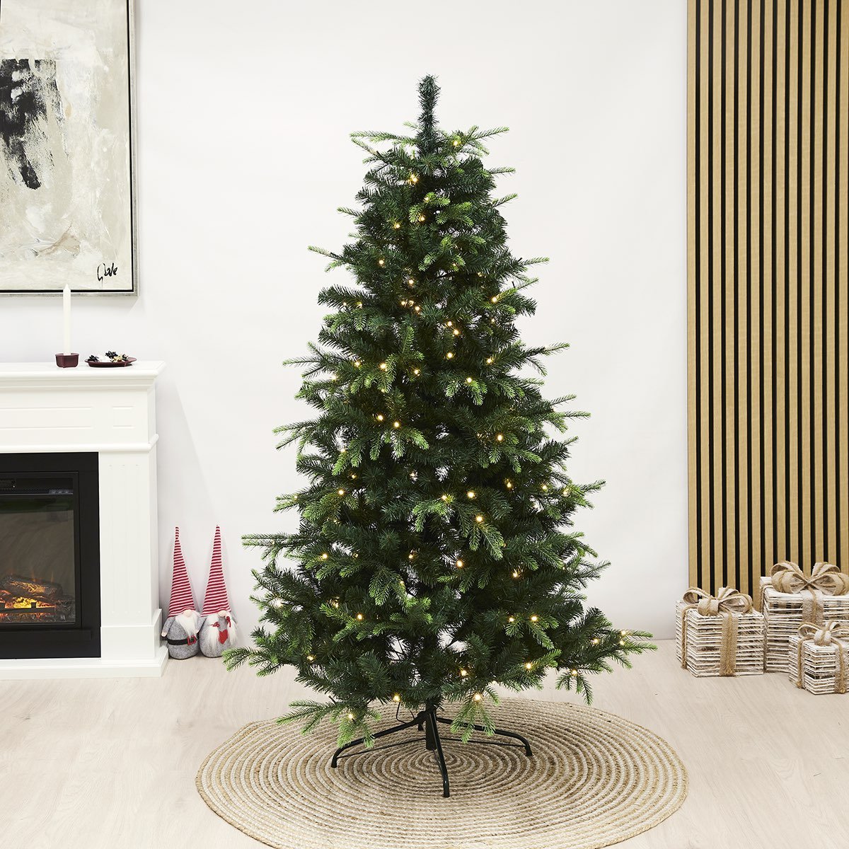 Kunstigt juletræ med LED-lys på fod Grønt kunstigt juletræ med varme LED-lys i stue