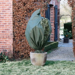 Vinterovertræk til krukkeplanter udendørs Havekrukke med plante dækket af grønt vinterovertræk