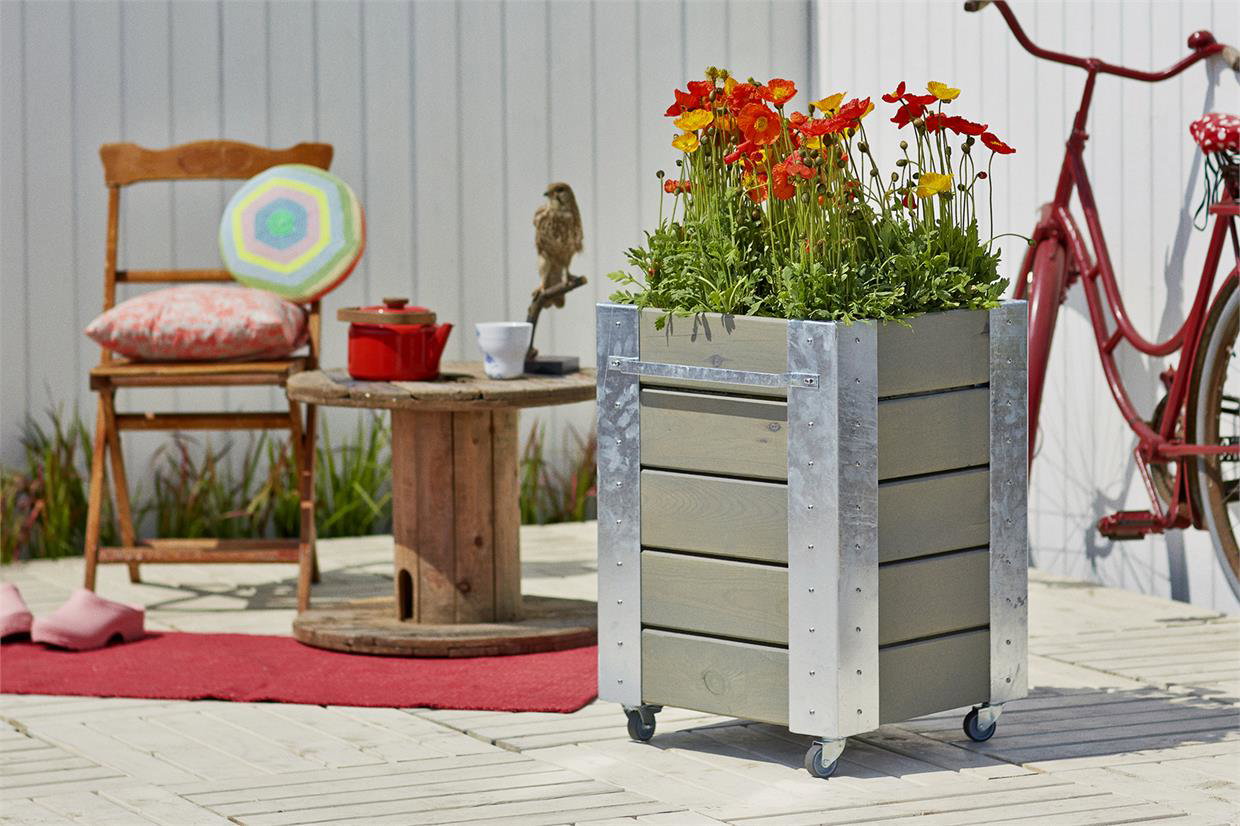 Rektangulær plantekasse på hjul med farverige blomster