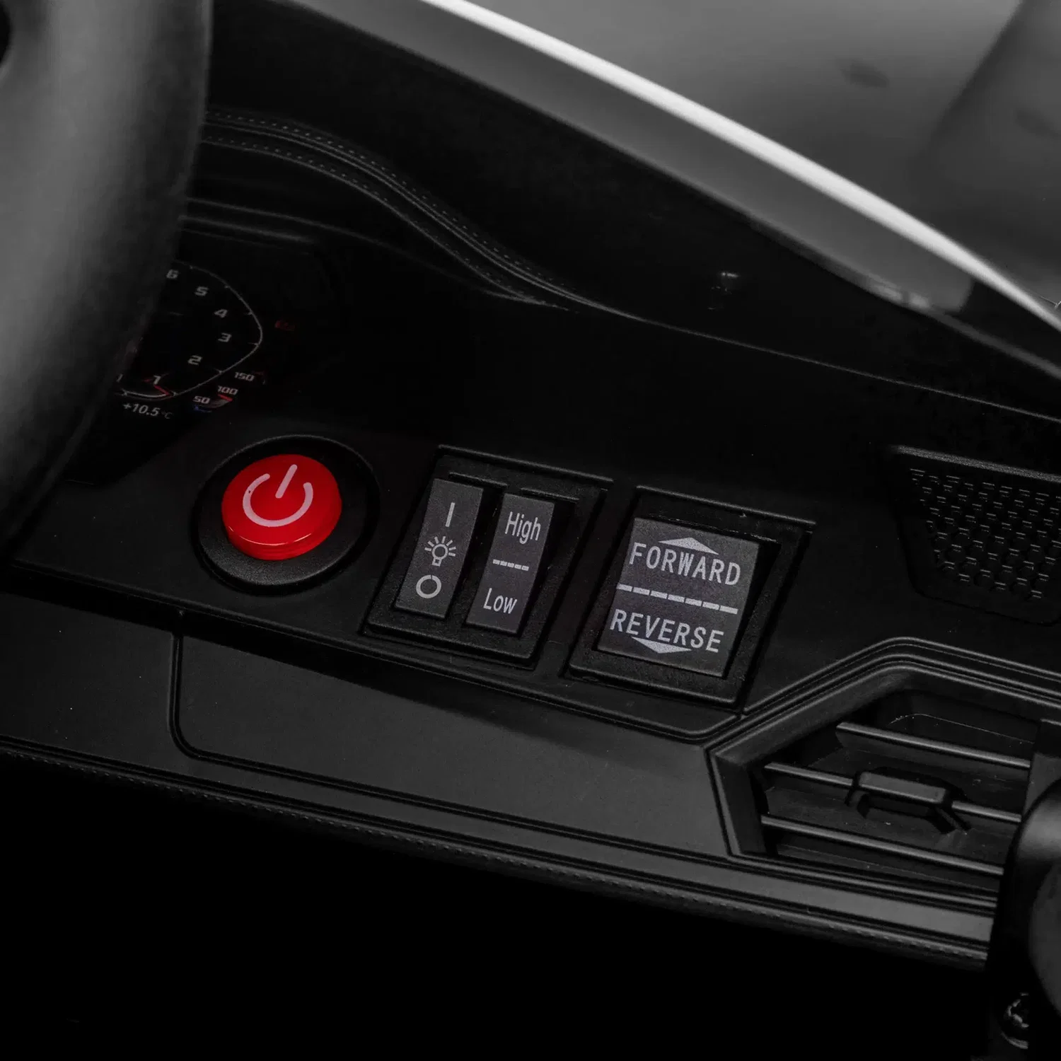 Detalje af instrumentpanel i sort BMW M4 elbil til børn fra NORDIC PLAY: rød tænd/sluk-knap, speed-omskifter (High/Low) og Forward/Reverse-knap. Licenseret børnebil med fjernbetjening, MP3 og Bluetooth.