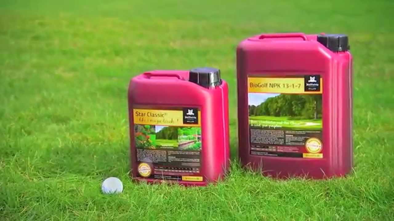 BioNutria Plænepakken Startpakke 15 L - plænegødning til grøn, mosfri græsplæne Foto af BioNutria Plænepakken startpakke fra Bionutria: to røde beholdere med plænegødning (15 L) placeret på grøn græsplæne ved en golfbane, til pleje af dybgrøn og mosfri plæne
