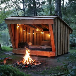 Shelter i lærketræ til 4 personer - BMB robust shelter 230x210 cm til overnatning i naturen Shelter i lærketræ til 4 personer fra BMB ved søen, åben front med frit udsyn, indvendigt 230 x 210 cm, hyggelig indretning med lyskæde og bålplads foran