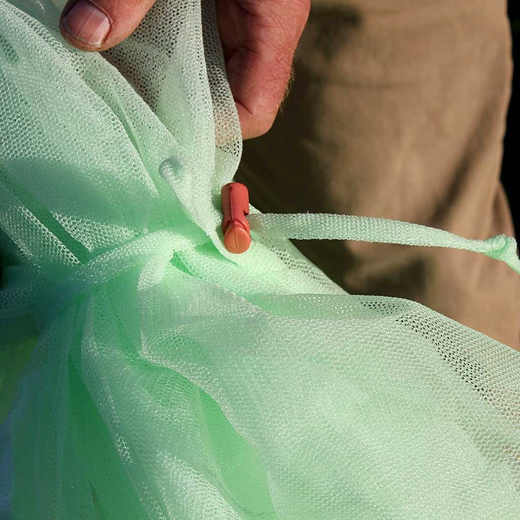 Grønt insektnet med snorstrammer Hånd strammer grønt insektnet med snor