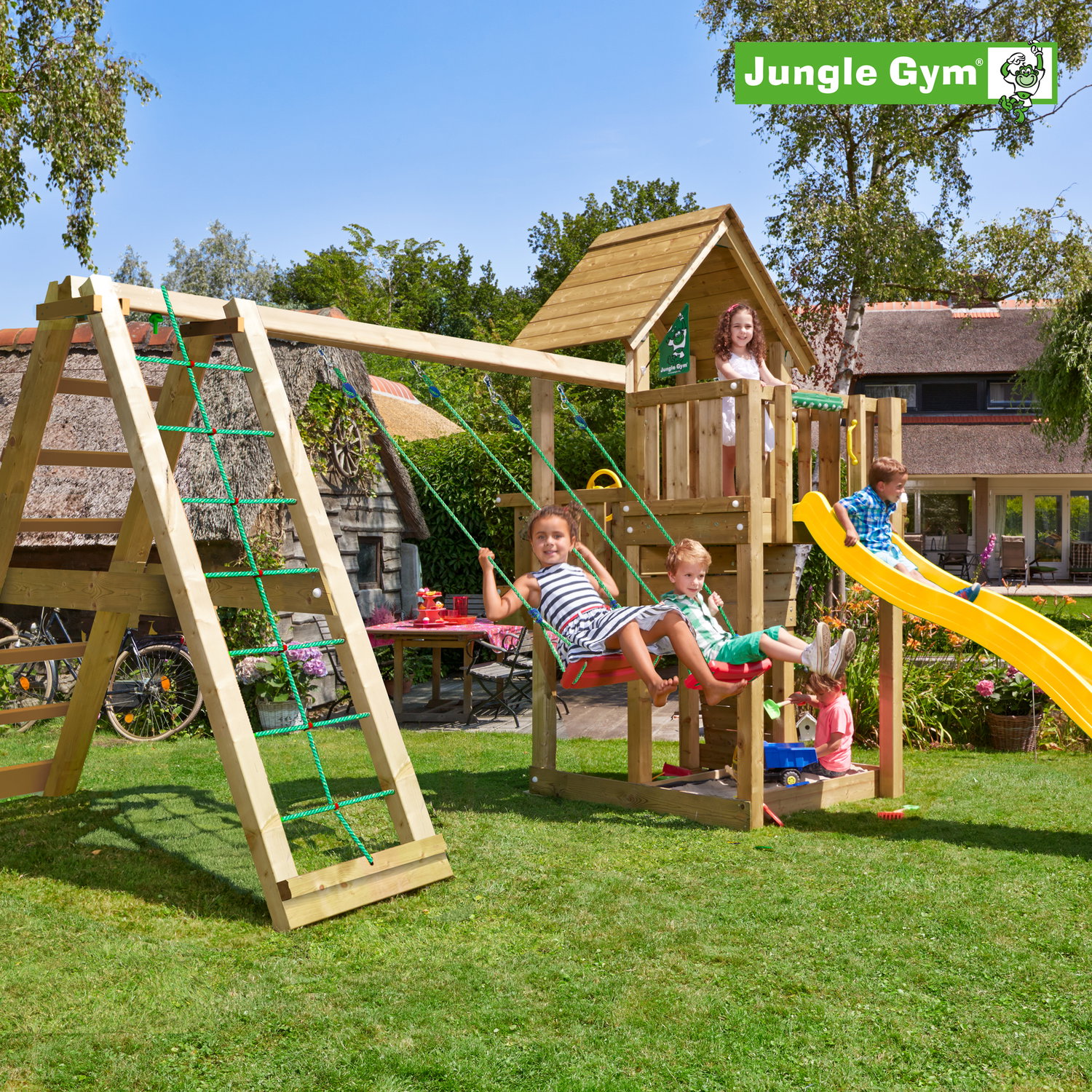 Jungle Gym legehus med gynge og rutsjebane Børn leger på Jungle Gym trælegeplads i haven
