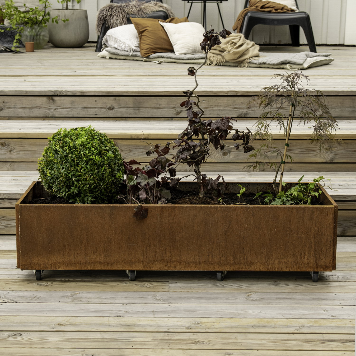 Rektangulær højbed i cortenstål på hjul Stor plantekasse i cortenstål på terrasse med planter