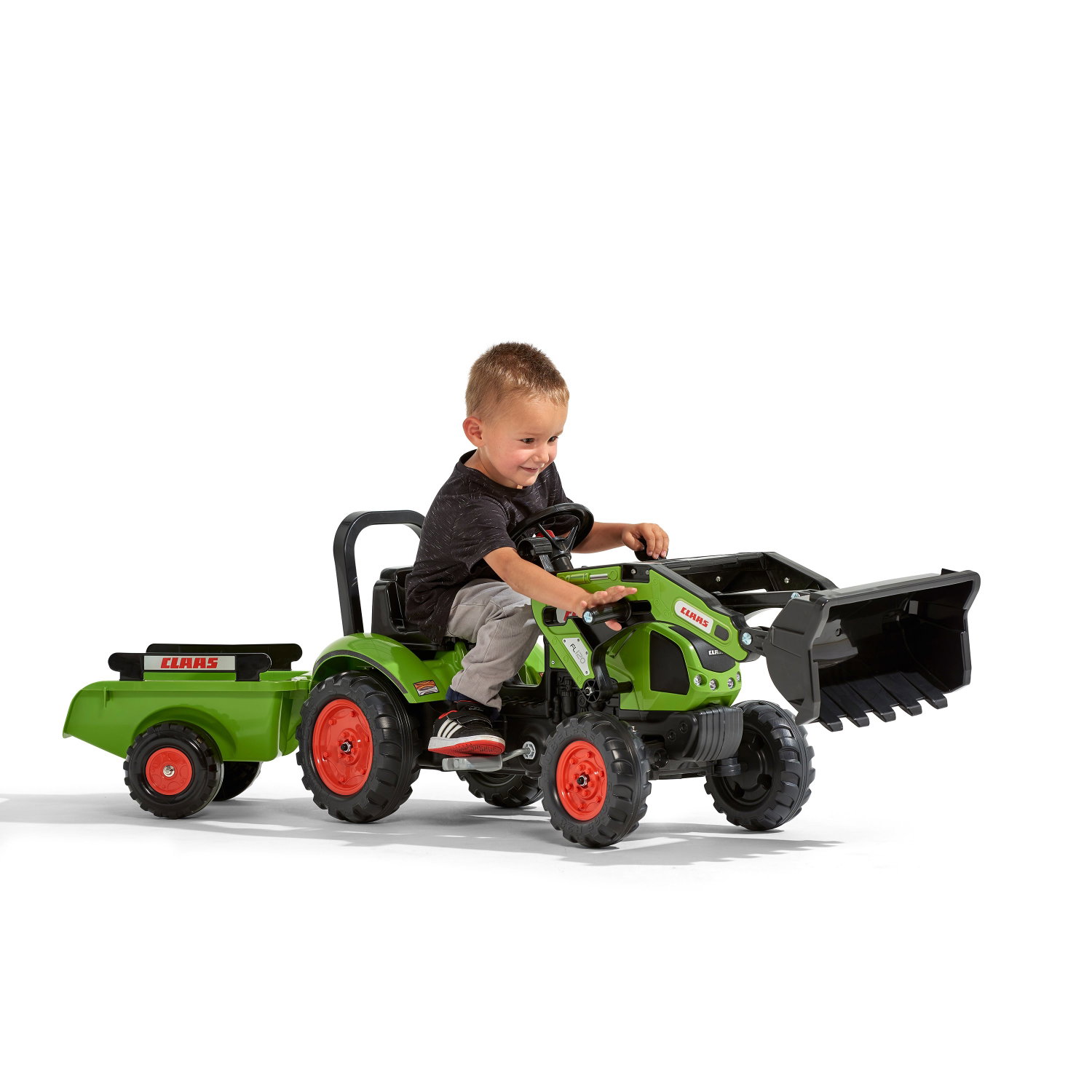 Dreng kører på grøn CLAAS pedaltraktor med trailer