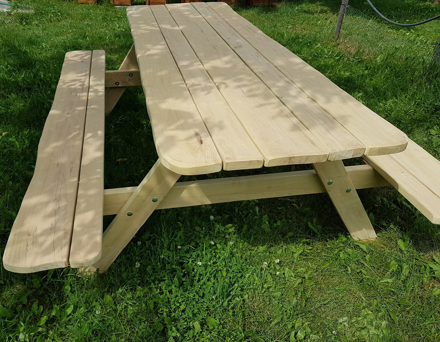Stor træbænkbord til haven Langt picnicbord i lyst træ med bænke i have