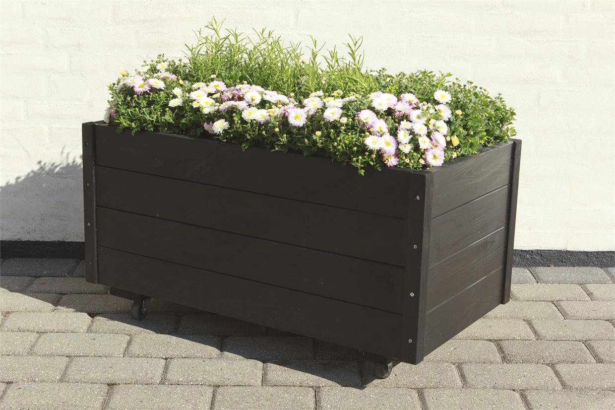 Sort rektangulær plantekasse på hjul med blomster