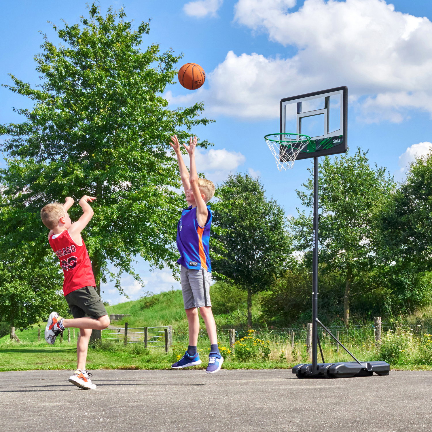 To drenge spiller basket ved flytbar kurv udenfor