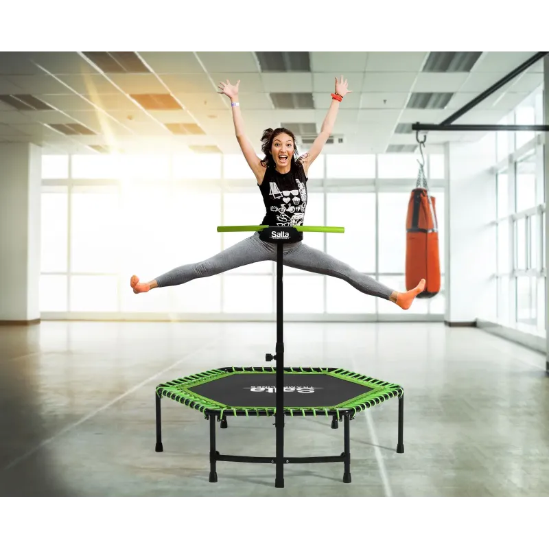 Fitness-trampolin med håndtag til indendørs træning Kvinde hopper på sekskantet fitness-trampolin med håndtag