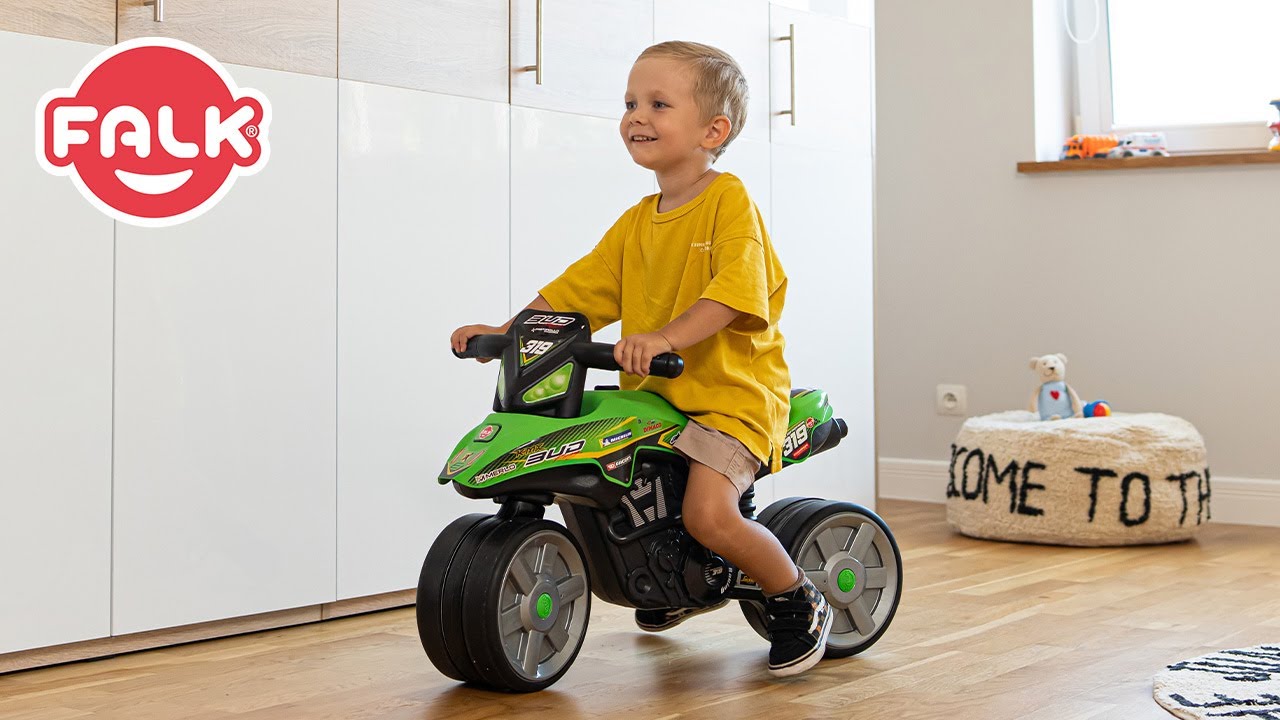 Barn sidder på grøn FALK Bud Racing balance motorcykel med lydløse hjul; inspireret af Grand Prix-design, velegnet til 2–5 år, 100% fremstillet i Frankrig og fremstillet af 40% genanvendt plastik