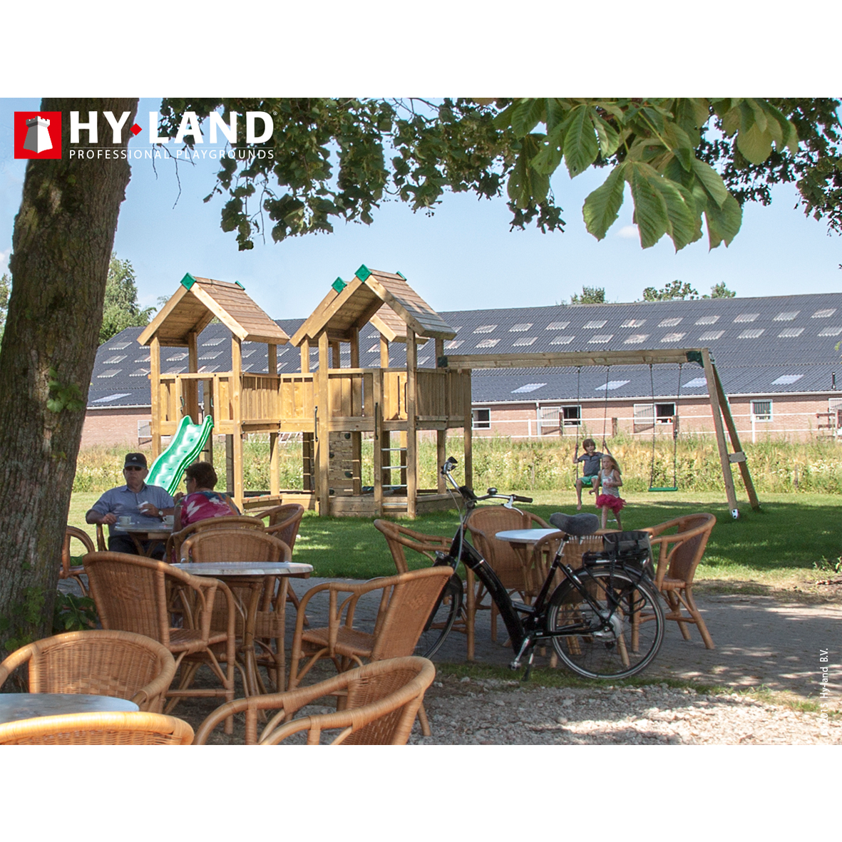 Hy-Land legeplads i træ med gynger og rutsjebane Udendørs Hy-Land trælegeplads ved café med gynger og rutsjeb