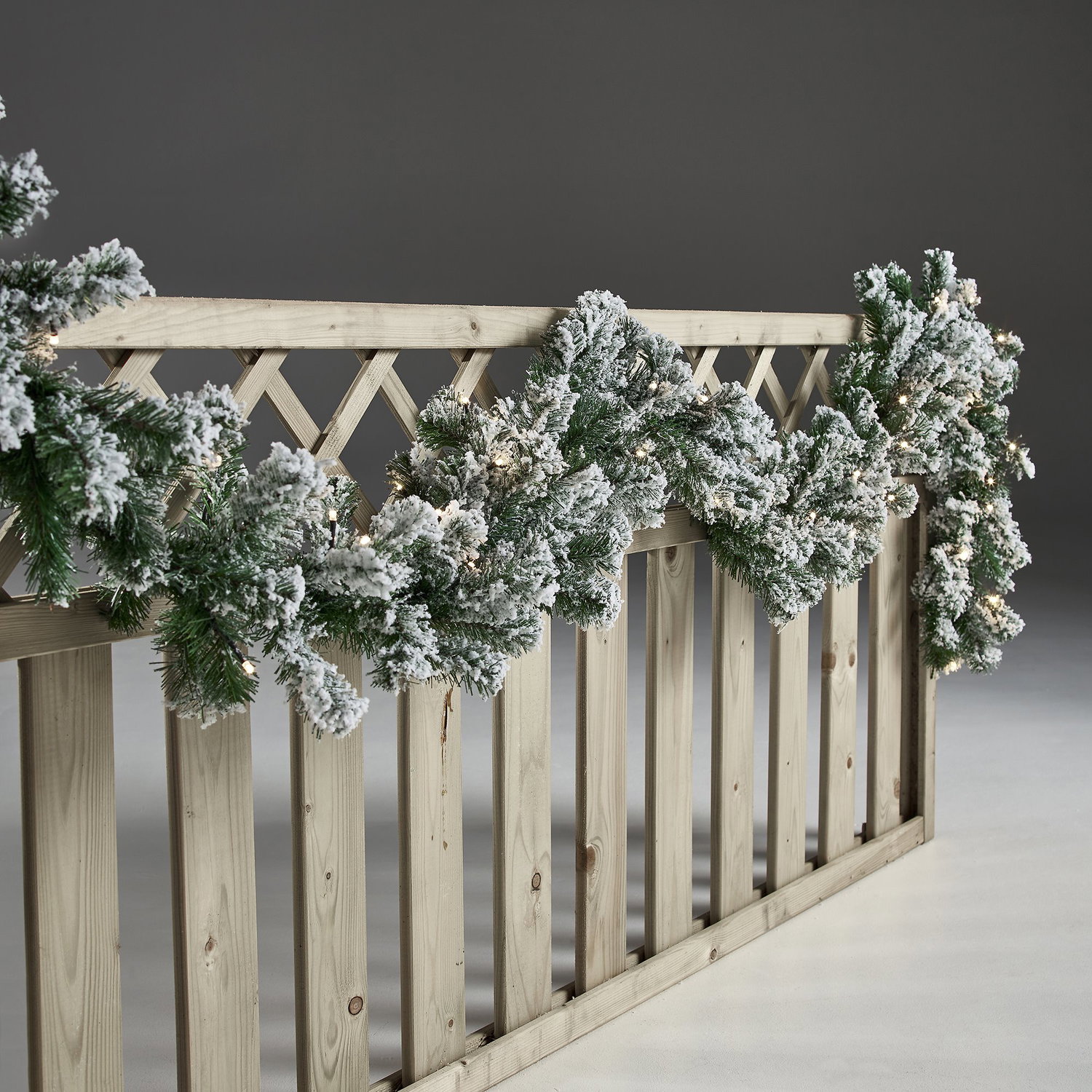 Grøn sneklædt juleguirlande med varme LED-lys