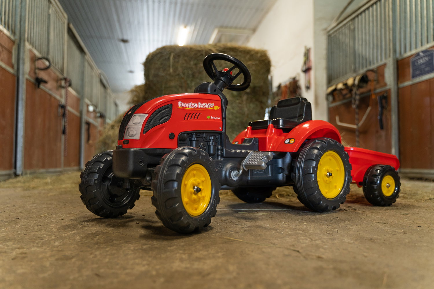 Rød pedaltraktor med vogn til børn Rød legetøjspedaltraktor med anhænger i stald