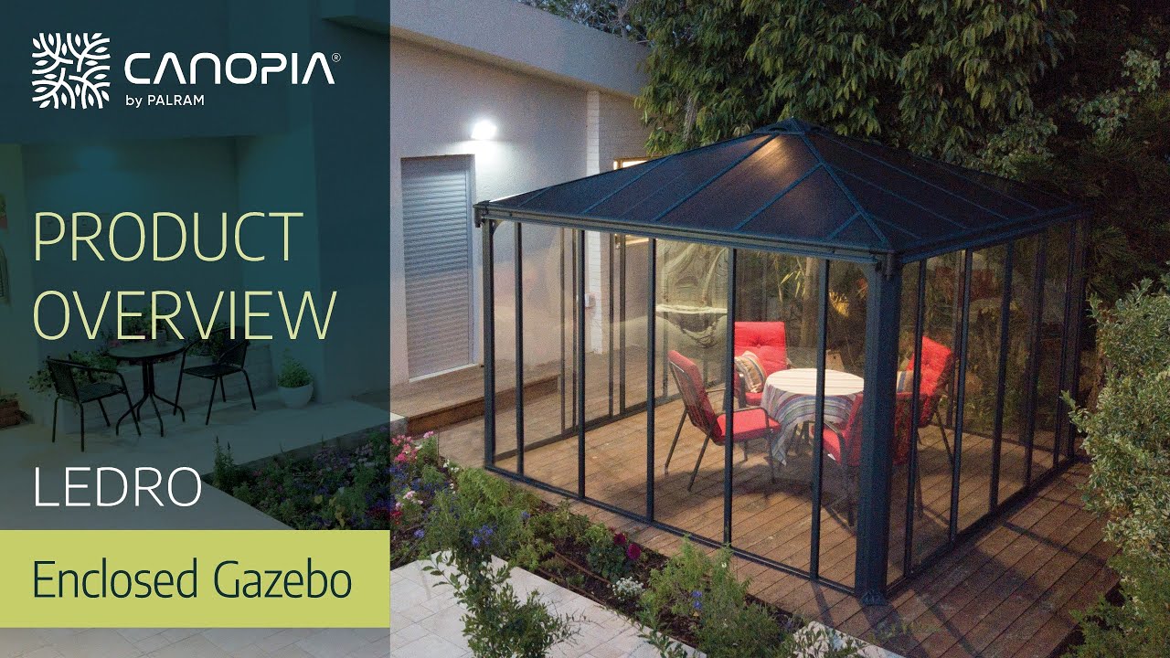 Palram Canopia Ledro 3000 lukket havepavillon i antracitgrå med pulverlakeret aluminiumskonstruktion, bronzefarvet tag og brede skydedøre; møbleret indendørs terrasse, elegant helårsudendørs løsning