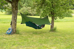 Grøn hængekøje med tarp opsat til camping mellem træer