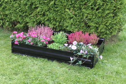 Sort højbed med blomster til haven Rektangulært sort højbed fyldt med farverige blomster