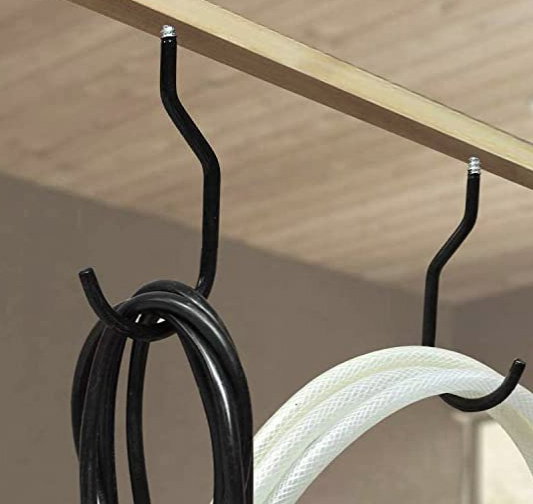 Sorte metalkroge ophængt med slanger i loft
