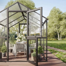 Moderne drivhus med dobbeltdør på terrasse Åbent glasdrivhus med spiseplads og grønne planter