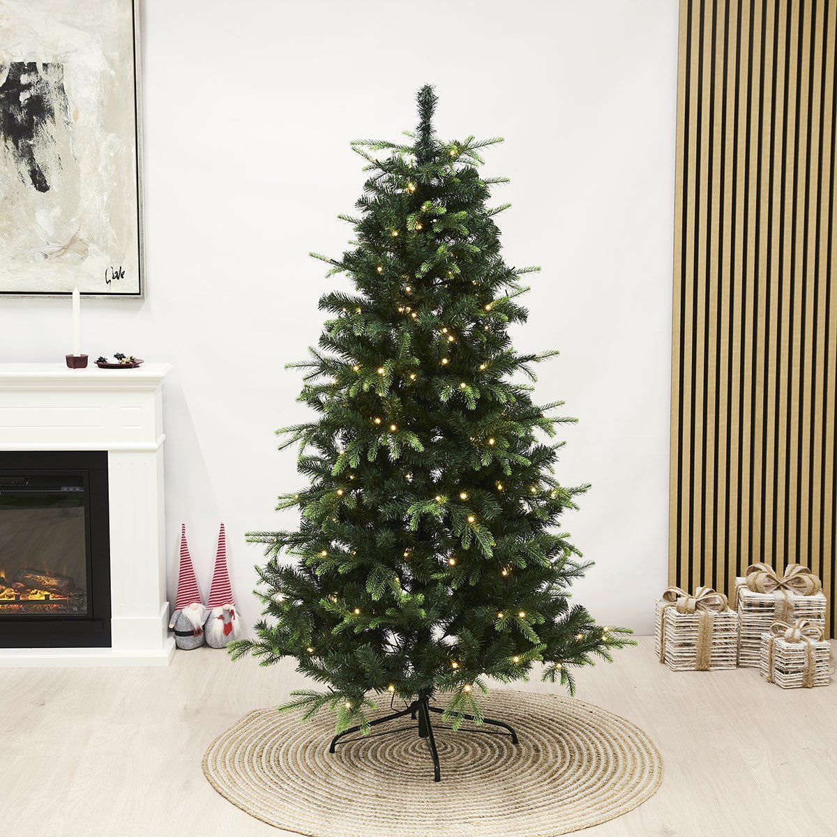 Kunstigt juletræ med LED-lys på fod Grønt kunstigt juletræ med varme LED-lys i stuen