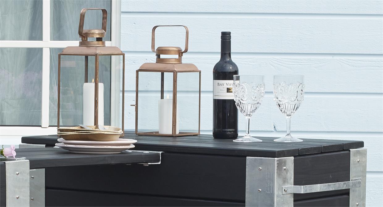 Sort havebord med lanterner, vinflaske og 2 glas