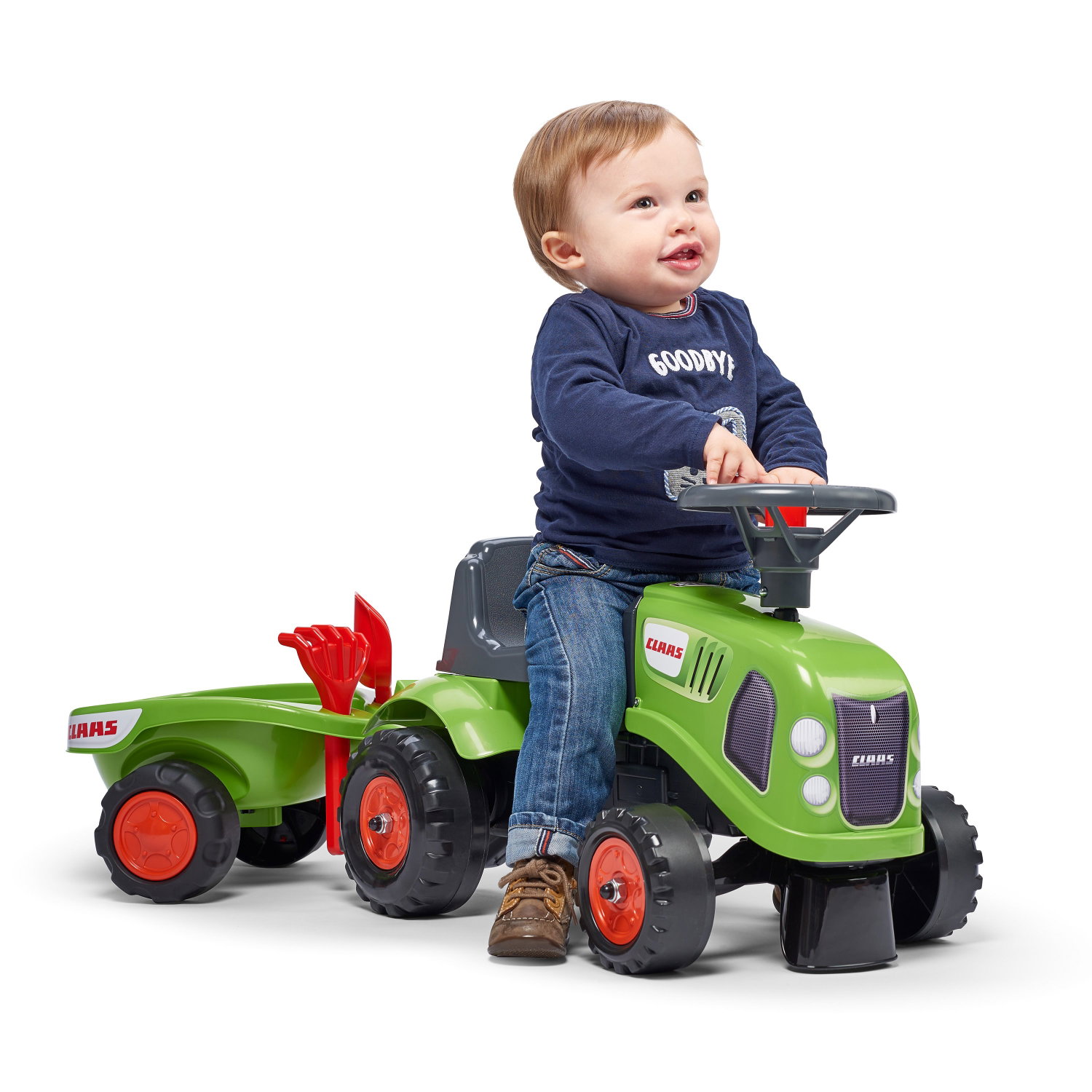 Lille barn kører på grøn CLAAS legetraktor med vogn