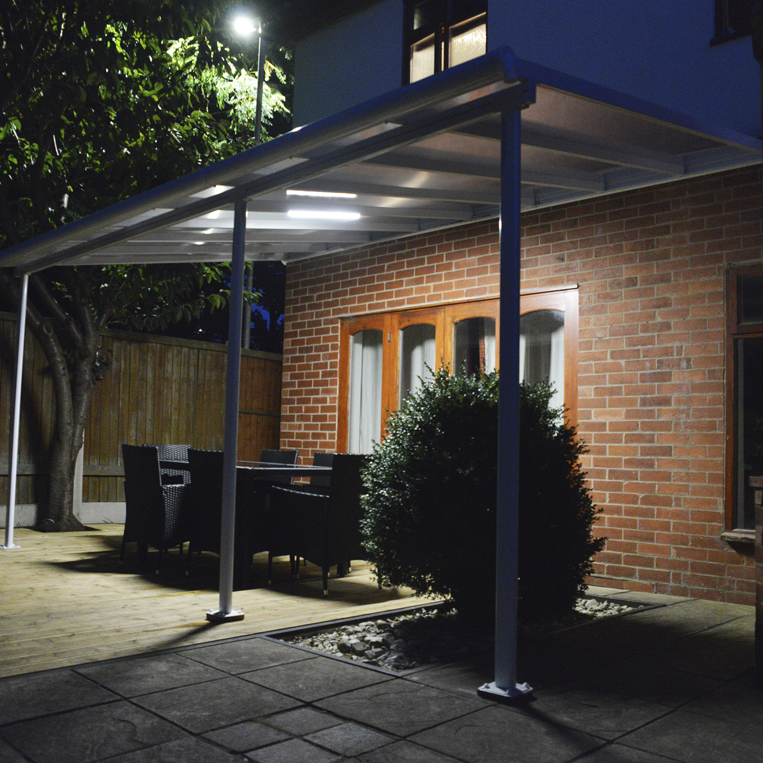 Moderne terrasseoverdækning med LED-lys Overdækket terrasse med udendørs spiseområde