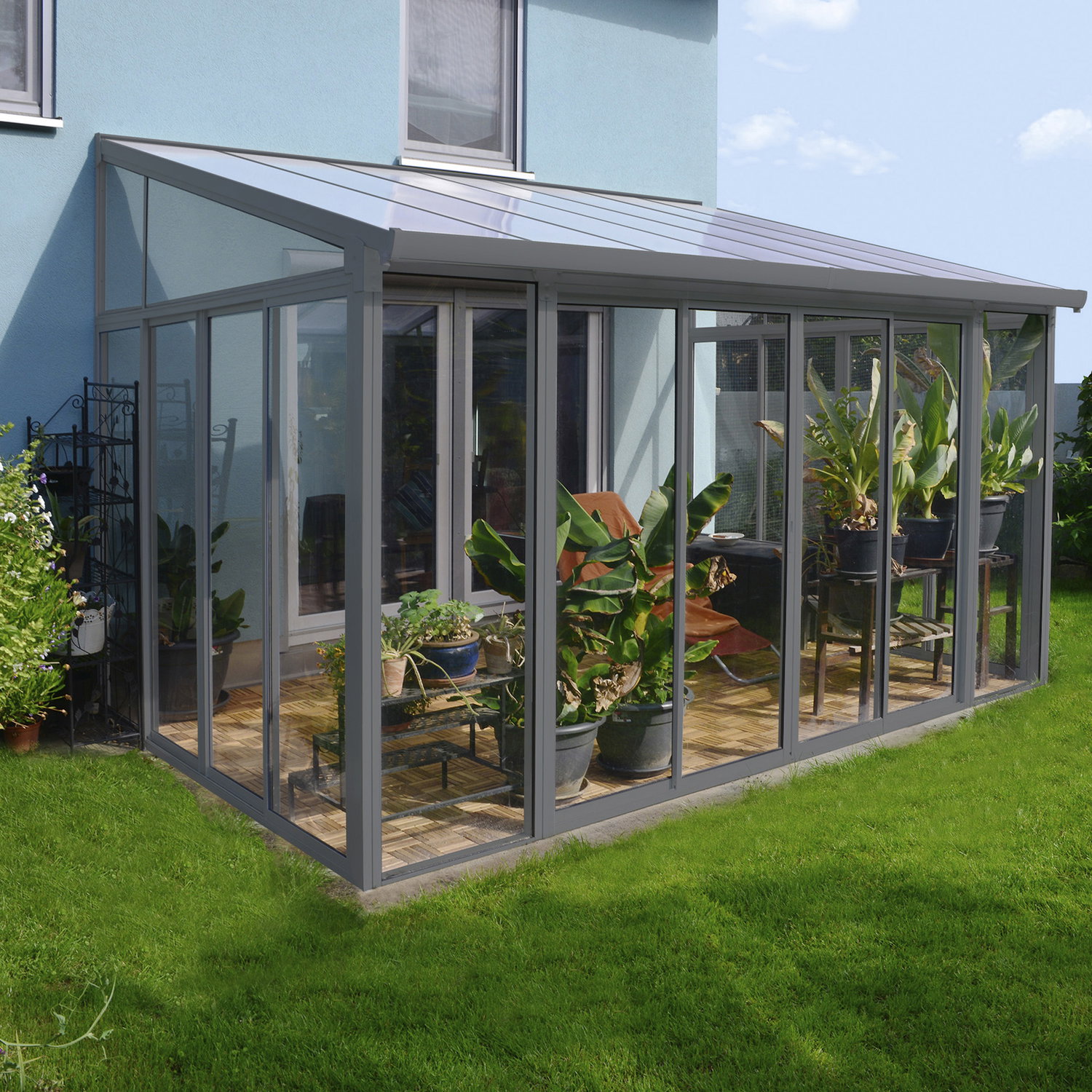 Elegantt glasudestue til terrasse og have Moderne glasudestue med planter ved husets terrasse
