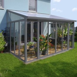 Moderne glasudestue med planter ved husets terrasse