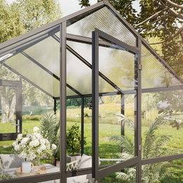 Moderne drivhus med glas og aluminium Elegant glasdrivhus i have med planter og sofa