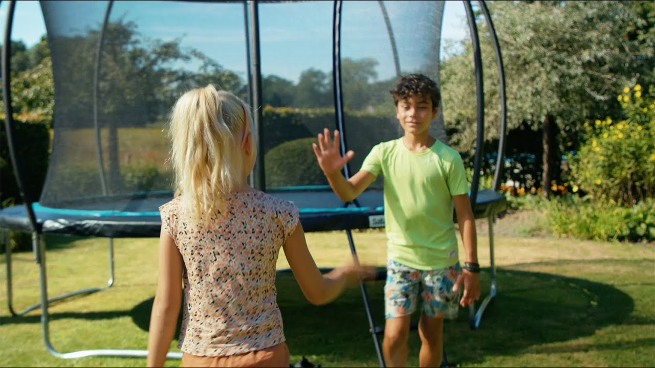 Børn leger foran Salta Trampolin Cosmos inkl. sikkerhedsnet Ø366 cm i en have – trampolin med robust ramme og beskyttende net fra Salta
