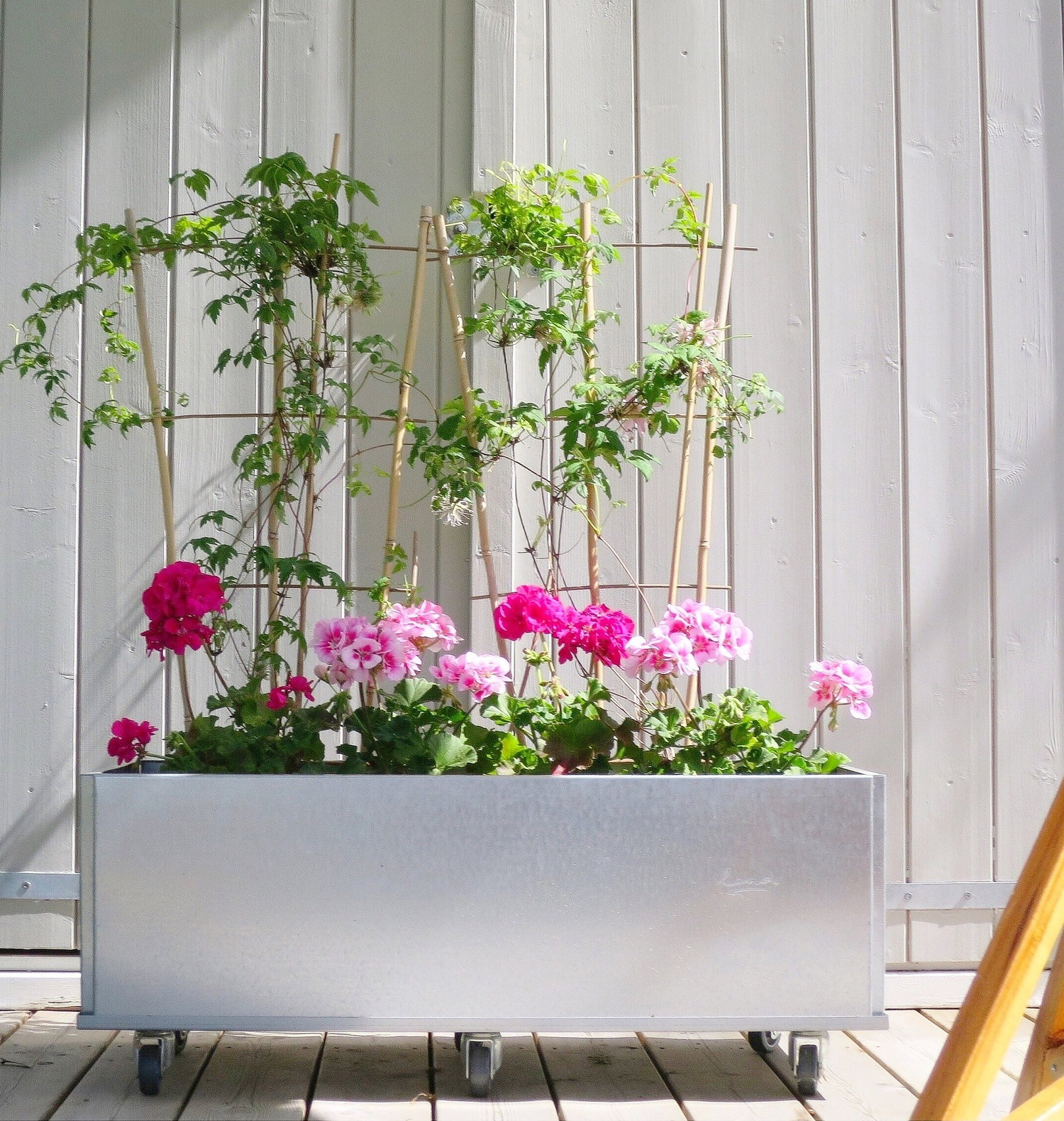 Mobil galvaniseret plantekasse med pink blomster