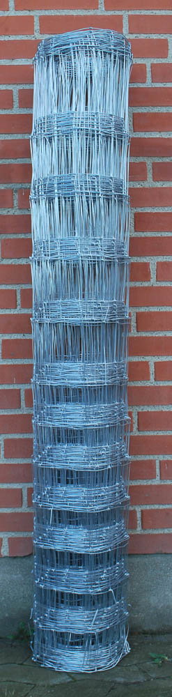 Rulle med galvaniseret trådhegn foran mur