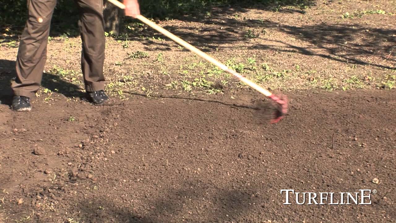 Person rager jævnt jord i forberedelse til såning af Turfline Classic "Den Rigtige" græsplæne – 2,5 kg græsfrø (Turfline-logo vist)