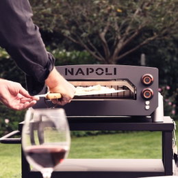 Napoli udendørs pizzaovn til haven Mand bager pizza i Napoli udendørs pizzaovn