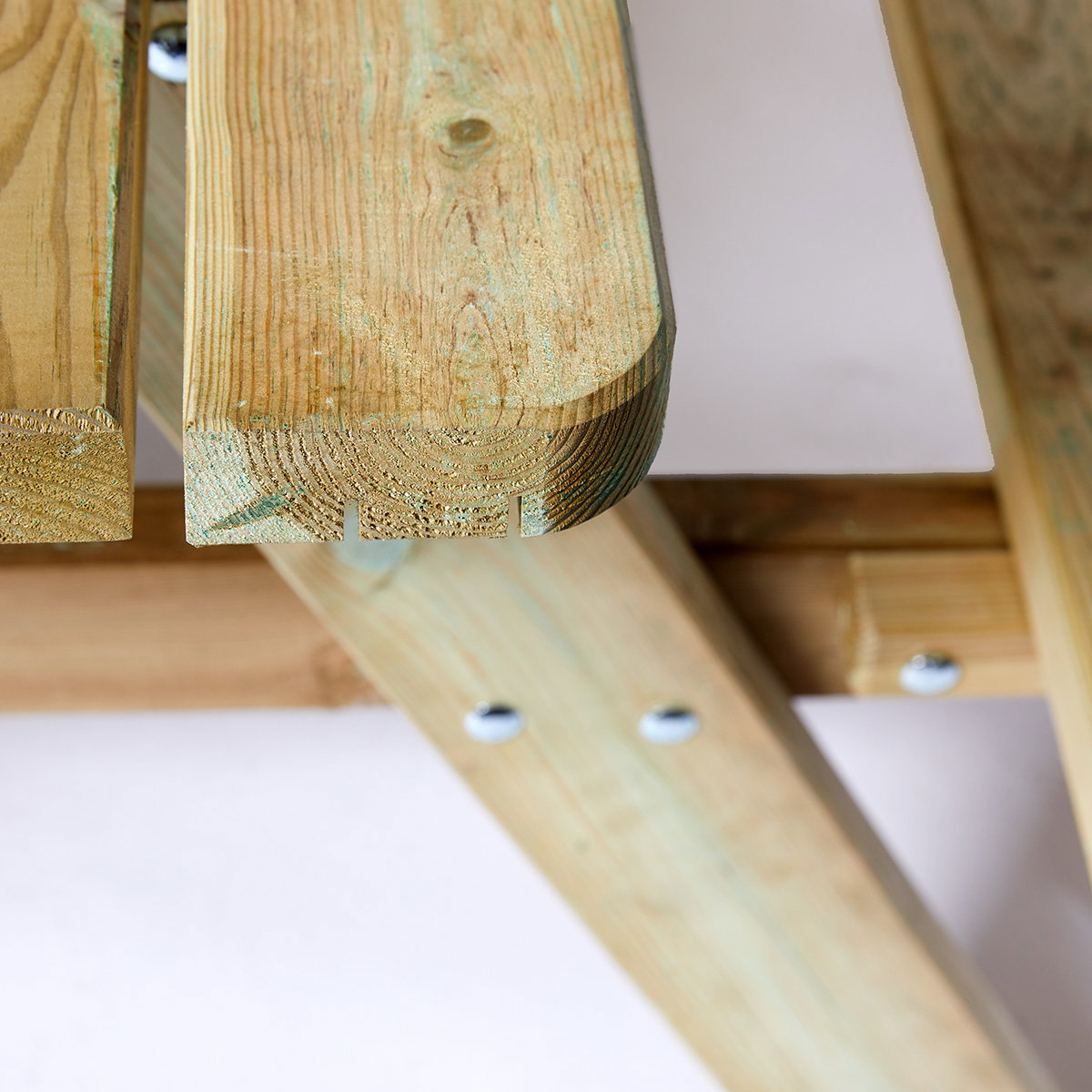Bord-/bænkesæt 42 mm XXL HORTUS - trykimprægneret fyrretræ, flip-up sæder, 300 cm picnicbord Nærbillede af kant og underside på HORTUS bord-/bænkesæt med 42 mm bordplade i trykimprægneret fyrretræ, viser træstruktur, samling og beslag til flip-up sæder