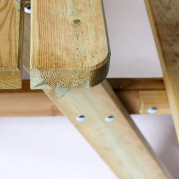 Bord-/bænkesæt 42 mm XXL HORTUS - trykimprægneret fyrretræ, flip-up sæder, 300 cm picnicbord Nærbillede af kant og underside på HORTUS bord-/bænkesæt med 42 mm bordplade i trykimprægneret fyrretræ, viser træstruktur, samling og beslag til flip-up sæder