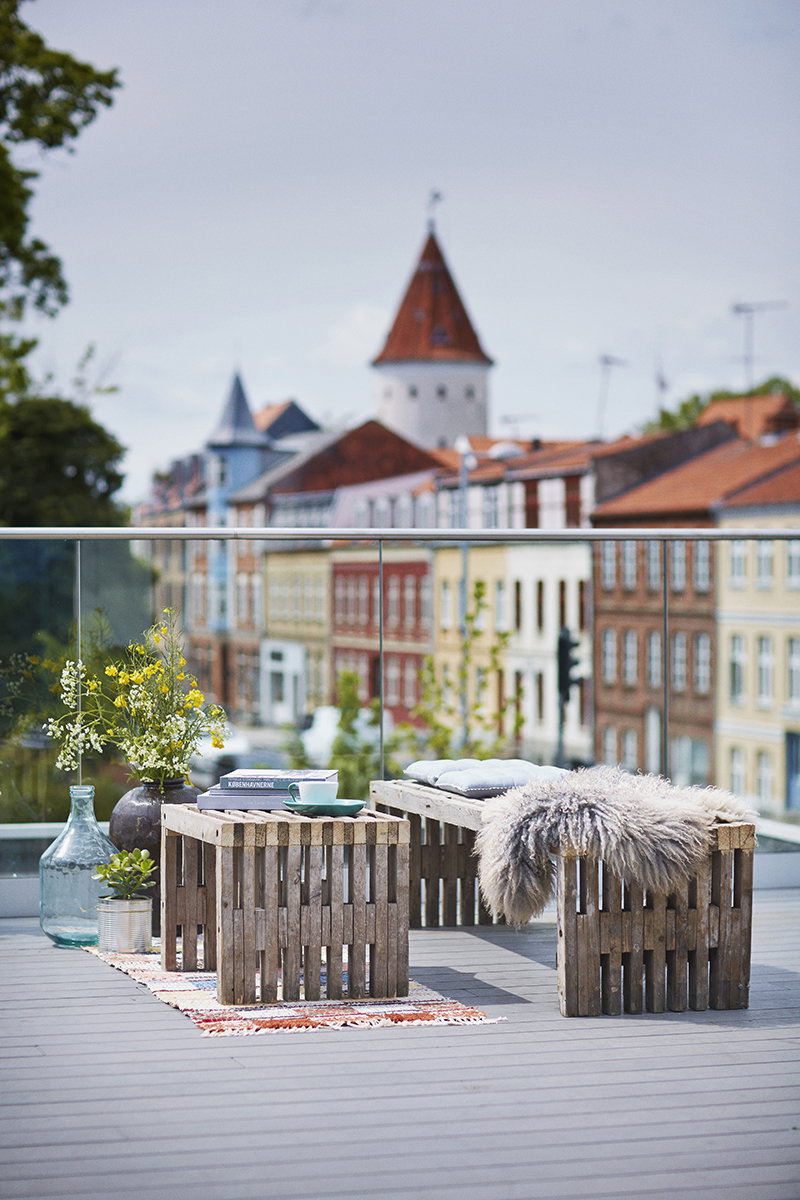 Hyggelig tagterrasse med byudsigt Hyggelig tagterrasse med træmøbler og byudsigt