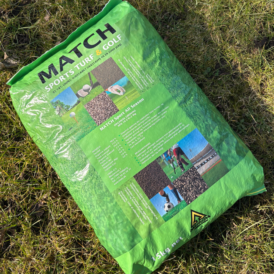 Sæk MEMON Match Sport plænegødning 15 kg (NPK 16-2-9 + 2,4 Mg) lagt på græs — langtidsvirkende organisk gødning, giver sund, grøn tilvækst og rækker til ca. 500–600 m²