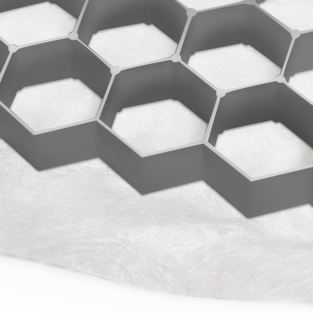 Nærbillede af grå honeycomb jordarmering på geotekstil