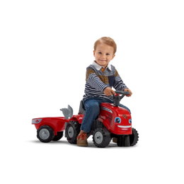 Rød pedaltraktor med trailer til børn Dreng kører på rød pedaltraktor med trailer