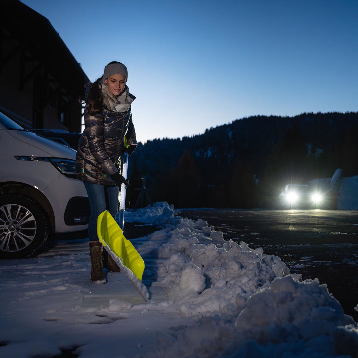 Freund Sneskovl REFLECTION 160 cm - neon-gult plastblad og ovalt aluskafte med refleks for øget synlighed Person rydder sne med Freund REFLECTION sneskovl 160 cm - neon-gult ribbeforstærket plastblad, høje sider og ovalt aluminiumsskaft med refleksfilm fra Freund Victoria