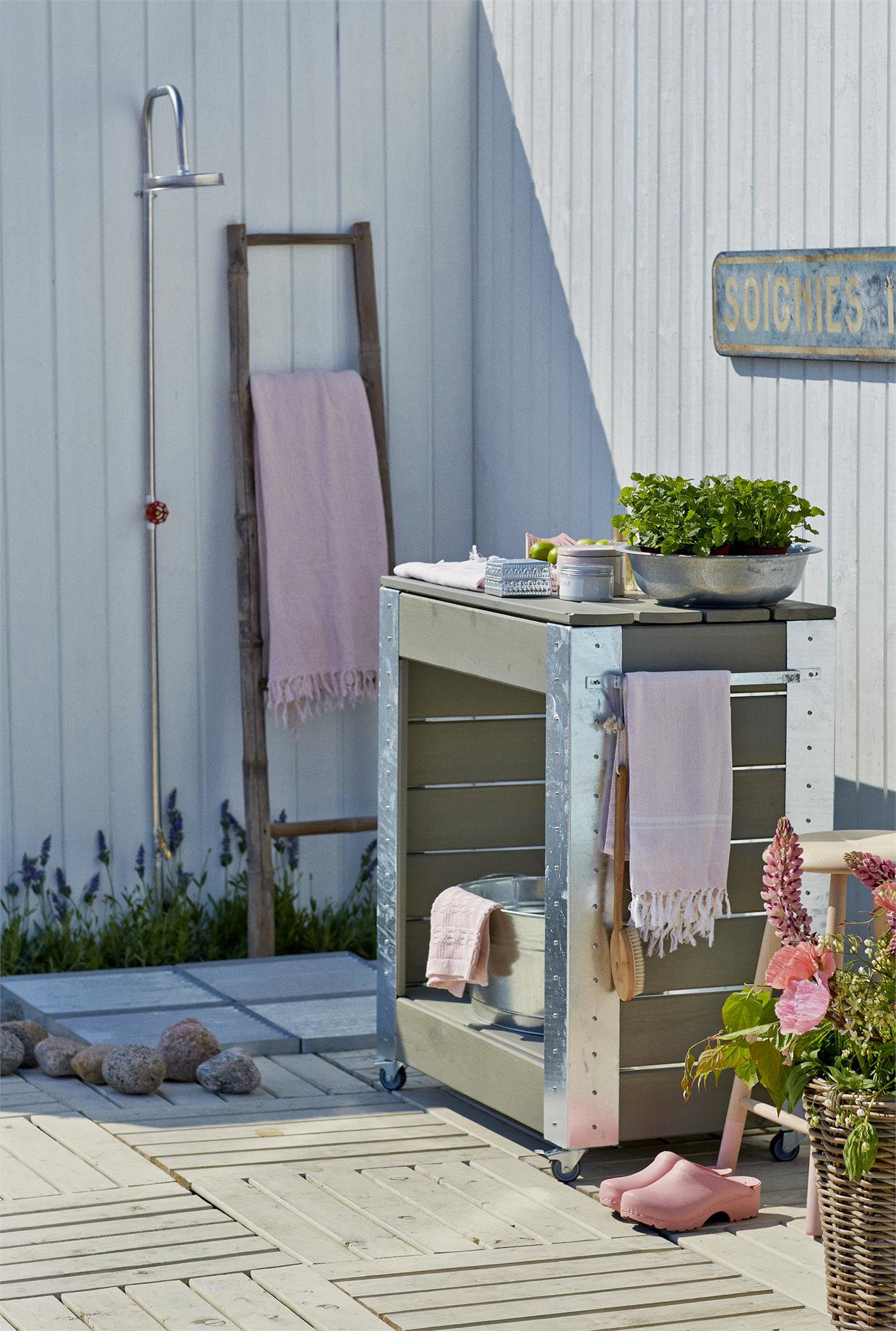 Lyst udendørs rullebord med planter og tilbehør på terrasse
