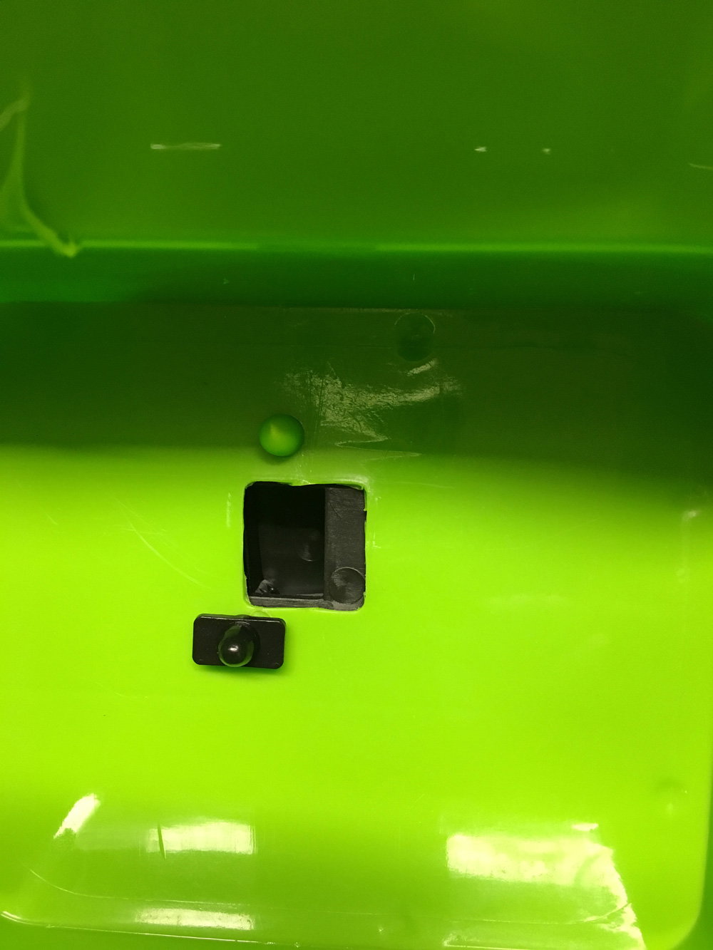 Grøn plastdel med firkantet udskæring Grøn plastoverflade med sort firkantet hul