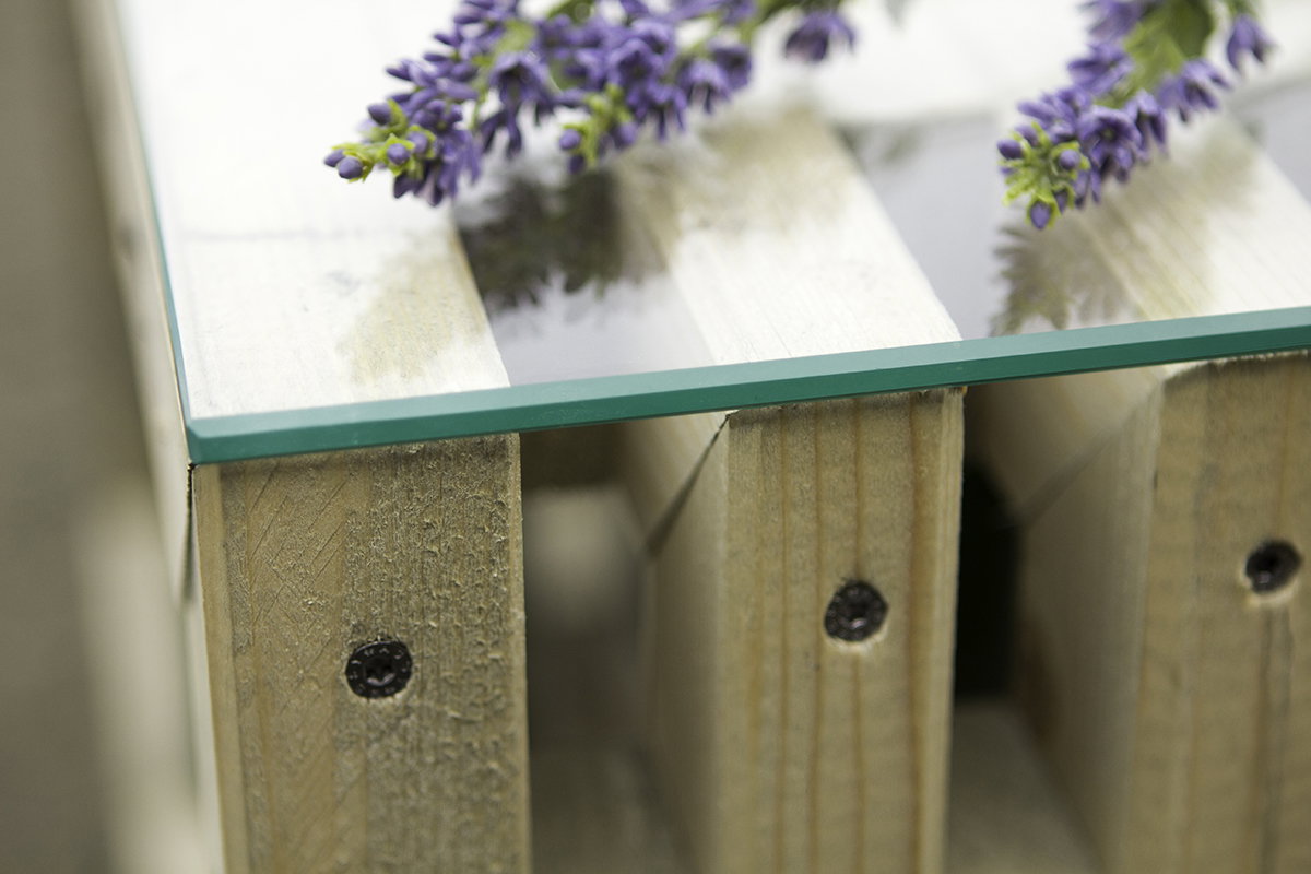 Klar glasplade på pallebord med lilla blomster