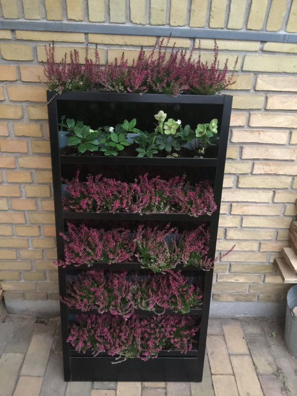 Vertikal plantekasse på altan med blomster