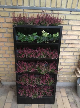 Vertikal plantekasse på altan med blomster