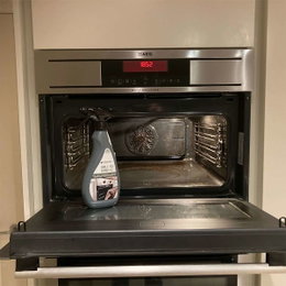 Grill- og ovnrens til effektiv ovnrengøring Flaske grill- og ovnrens foran åben ovn