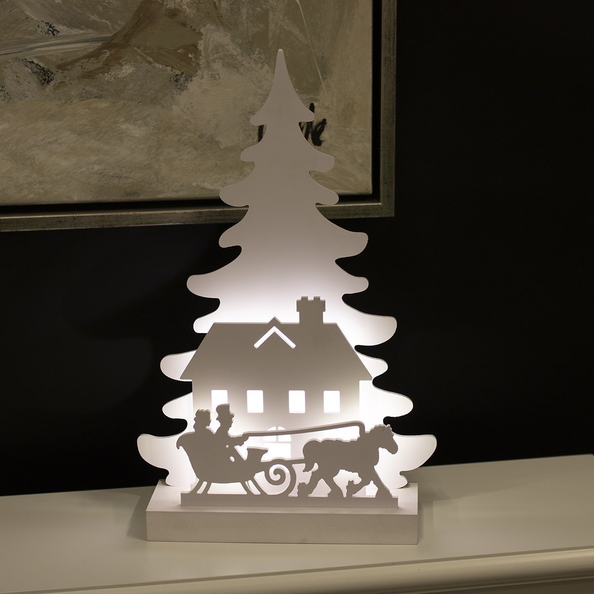 Lysende juledekoration med hus og kane Hvid LED-julefigur med hus og kane foran træ